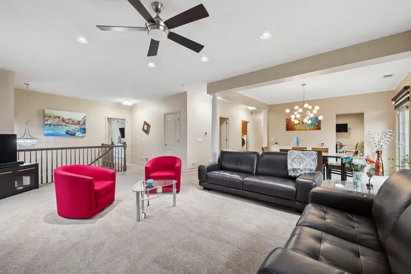 a living room with furniture kitchen view and a window