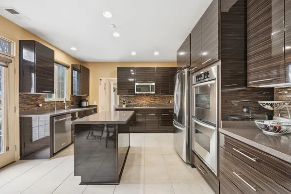 a kitchen with stainless steel appliances kitchen island granite countertop a refrigerator and stove