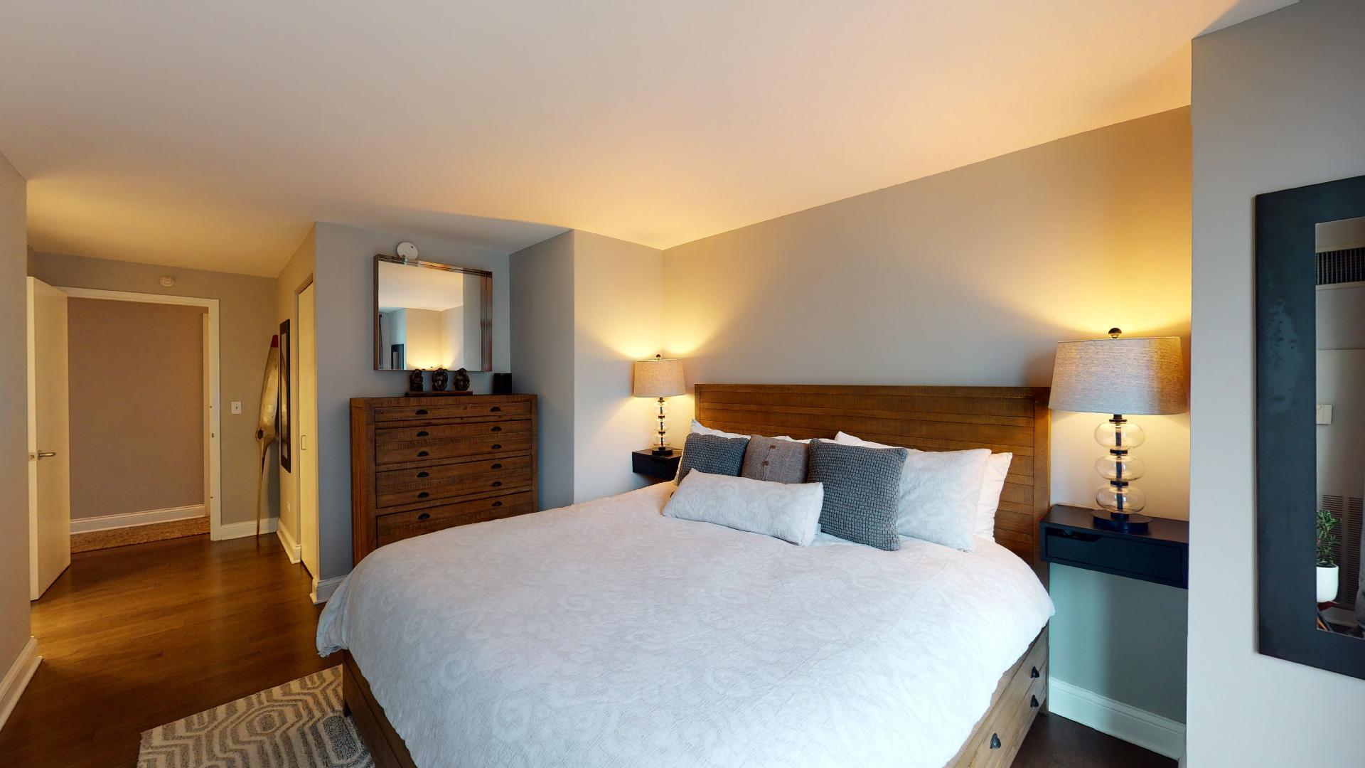 2 East Erie Street, Unit 3605 Chicago, IL 60611 - Photo 20 of 30 a bedroom with a bed and a chandelier