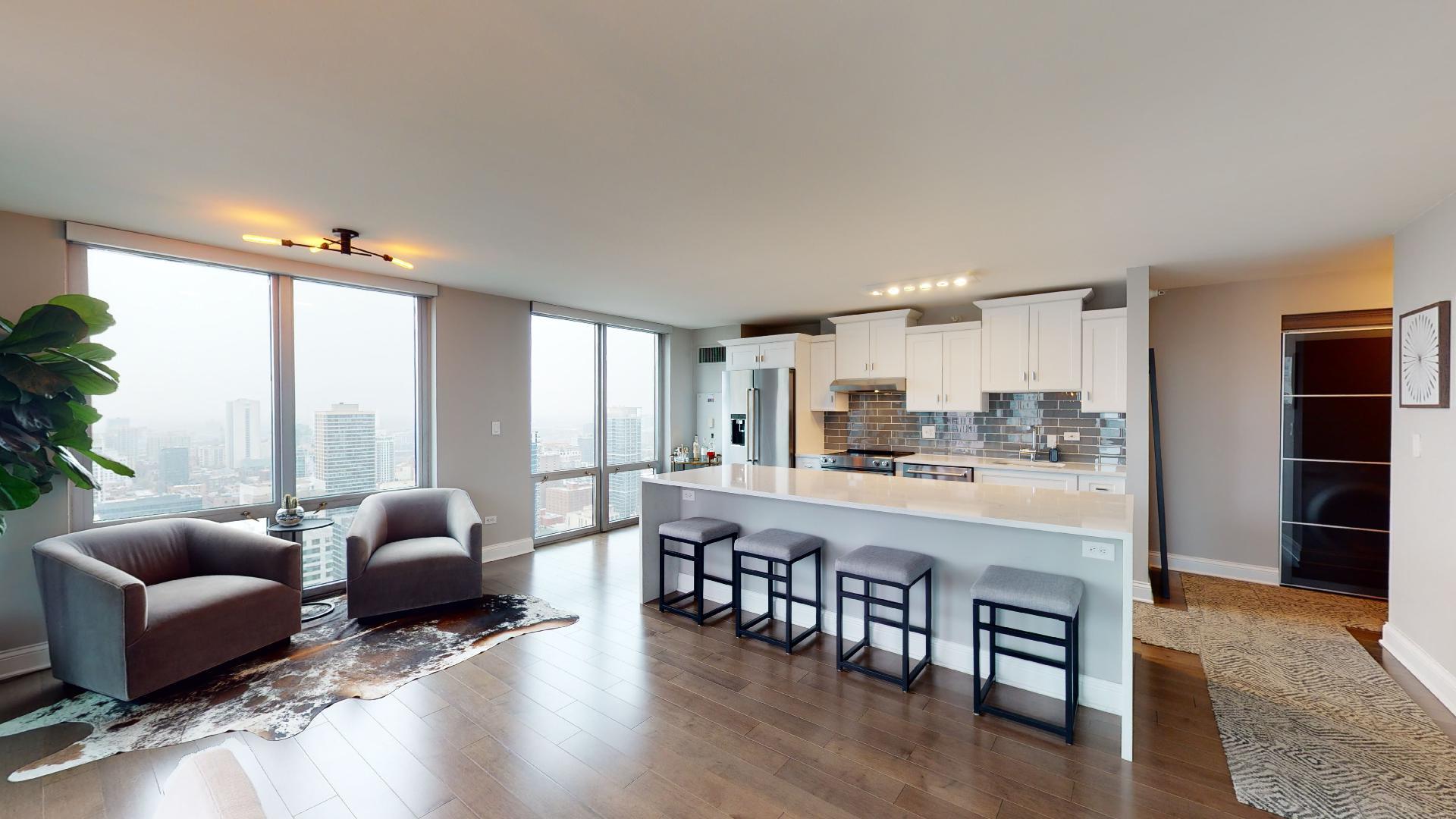 2 East Erie Street, Unit 3605 Chicago, IL 60611 - Photo 8 of 30 a large living room with stainless steel appliances granite countertop a couch and a large window with wooden floor