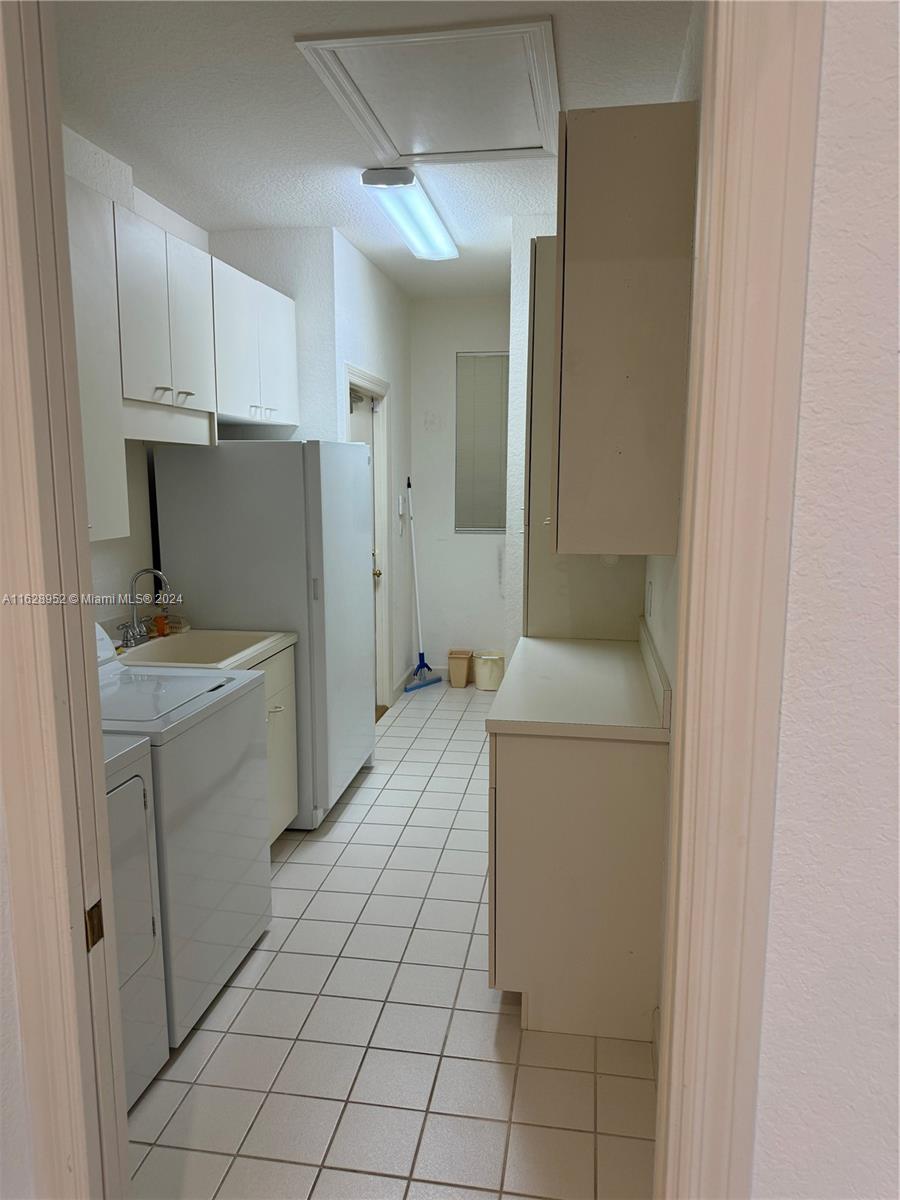 2743 Pinehurst Drive Weston, FL 33332 - Photo 6 of 35 a utility room with cabinets washer and dryer
