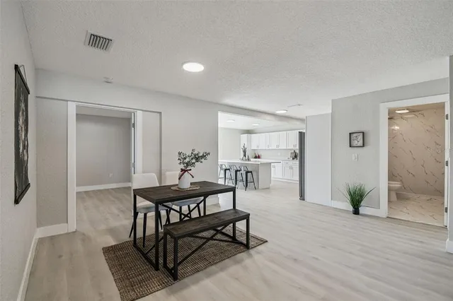 a kitchen with a table chairs sink and cabinets
