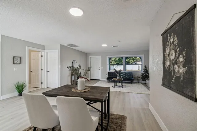 a kitchen with stainless steel appliances a refrigerator a stove a sink dishwasher and white cabinets with wooden floor