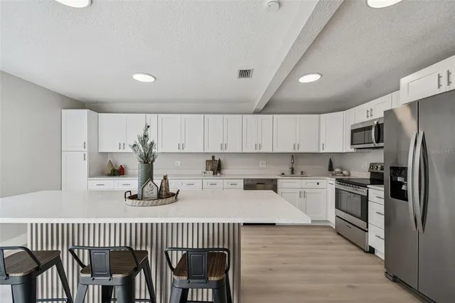 a kitchen with cabinets stainless steel appliances and sink