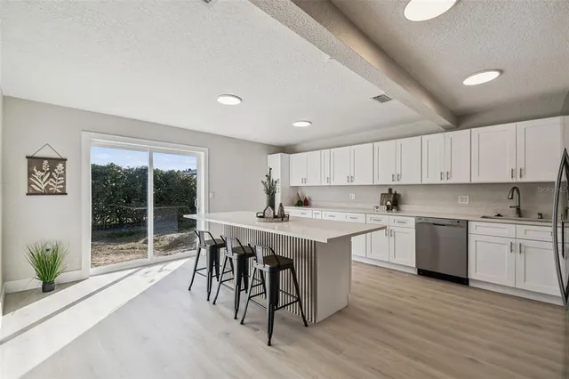 a kitchen with white cabinets and stainless steel appliances