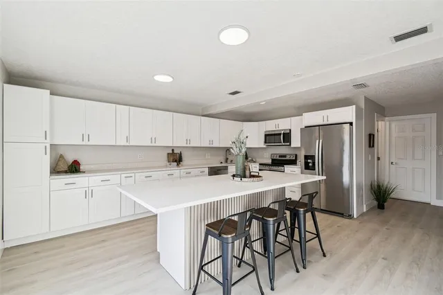 a kitchen with white cabinets and a sink