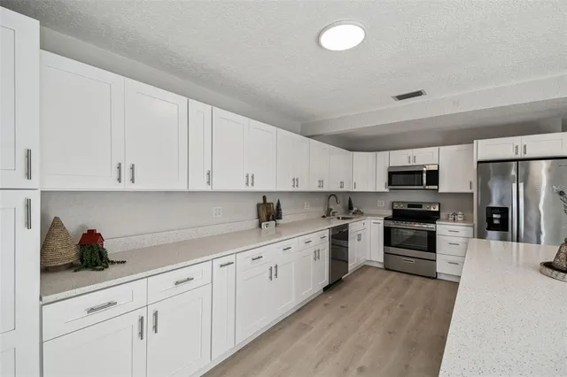 a kitchen with granite countertop a sink stove and cabinets