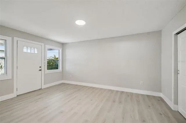 a view of a room that has wooden floor and window in it