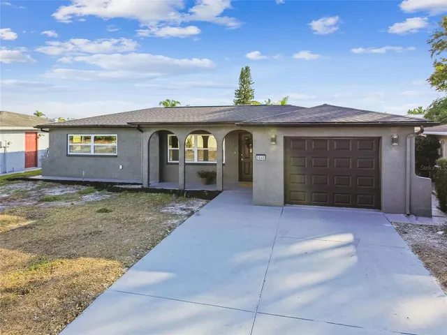 a view of a house with a yard and sitting area