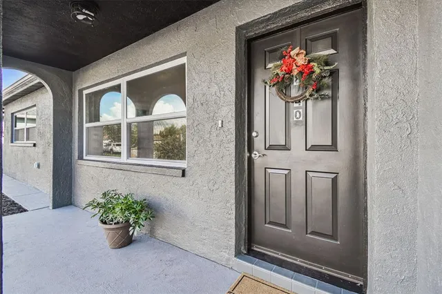 a vase of flowers sitting on a floor next to a window