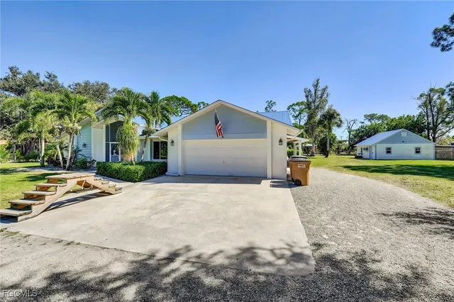 a view of a house with a yard and palm trees