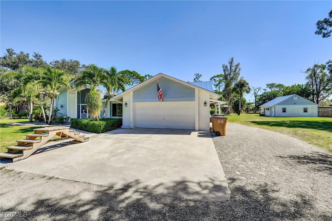 a view of a house with a yard and palm trees