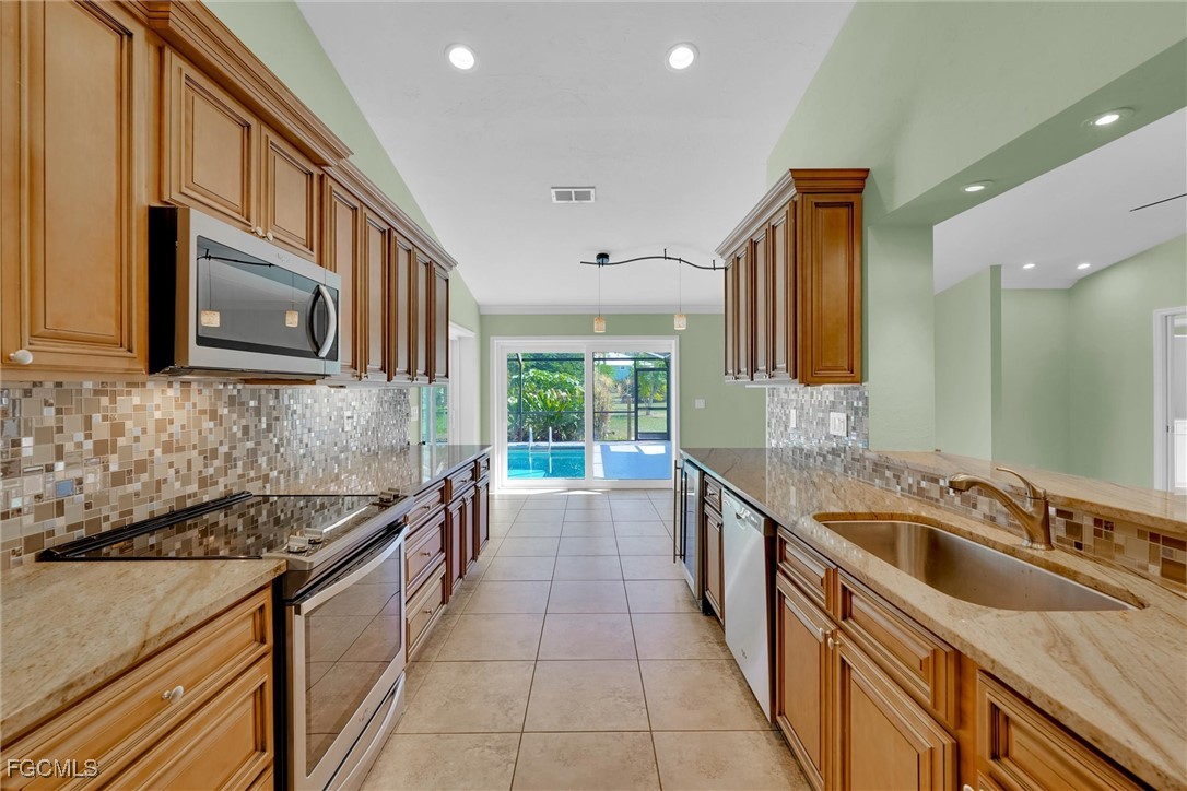 17040 Pleasure Road Cape Coral, FL 33909 - Photo 12 of 38 a kitchen with a sink stove and microwave