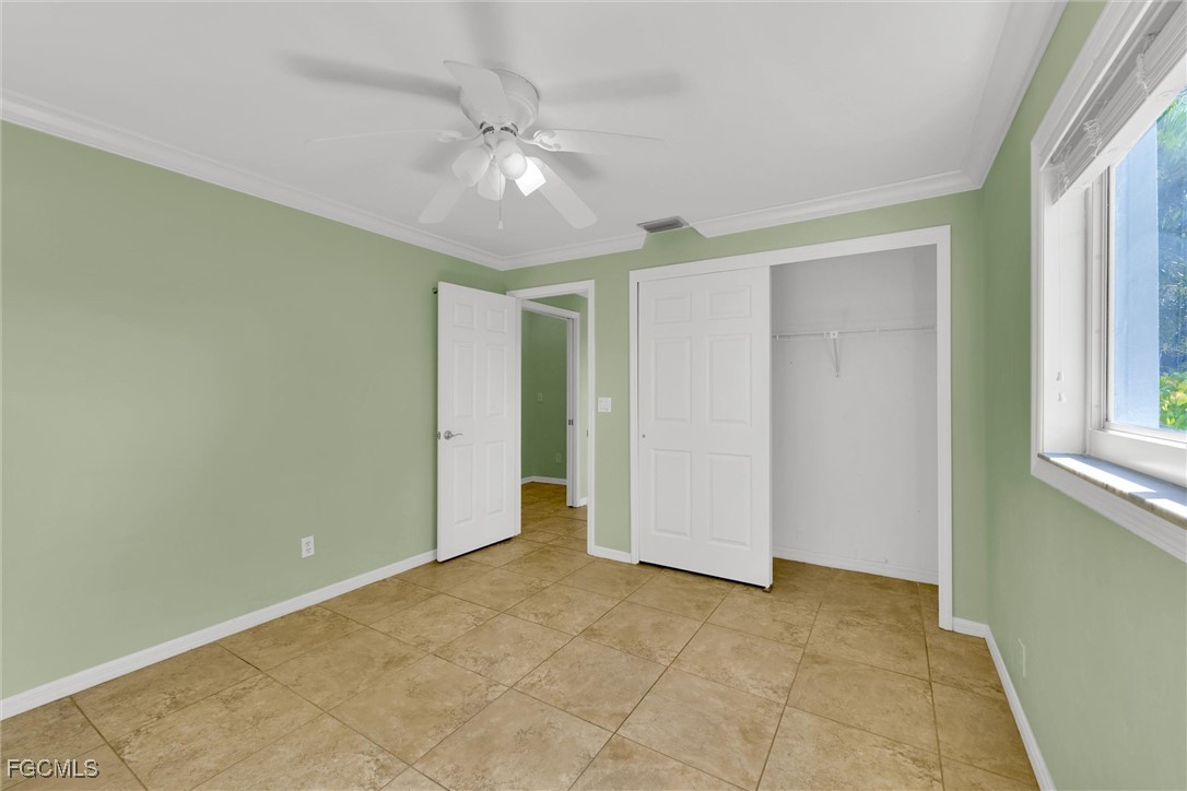 17040 Pleasure Road Cape Coral, FL 33909 - Photo 22 of 38 a view of an empty room with window and chandelier fan