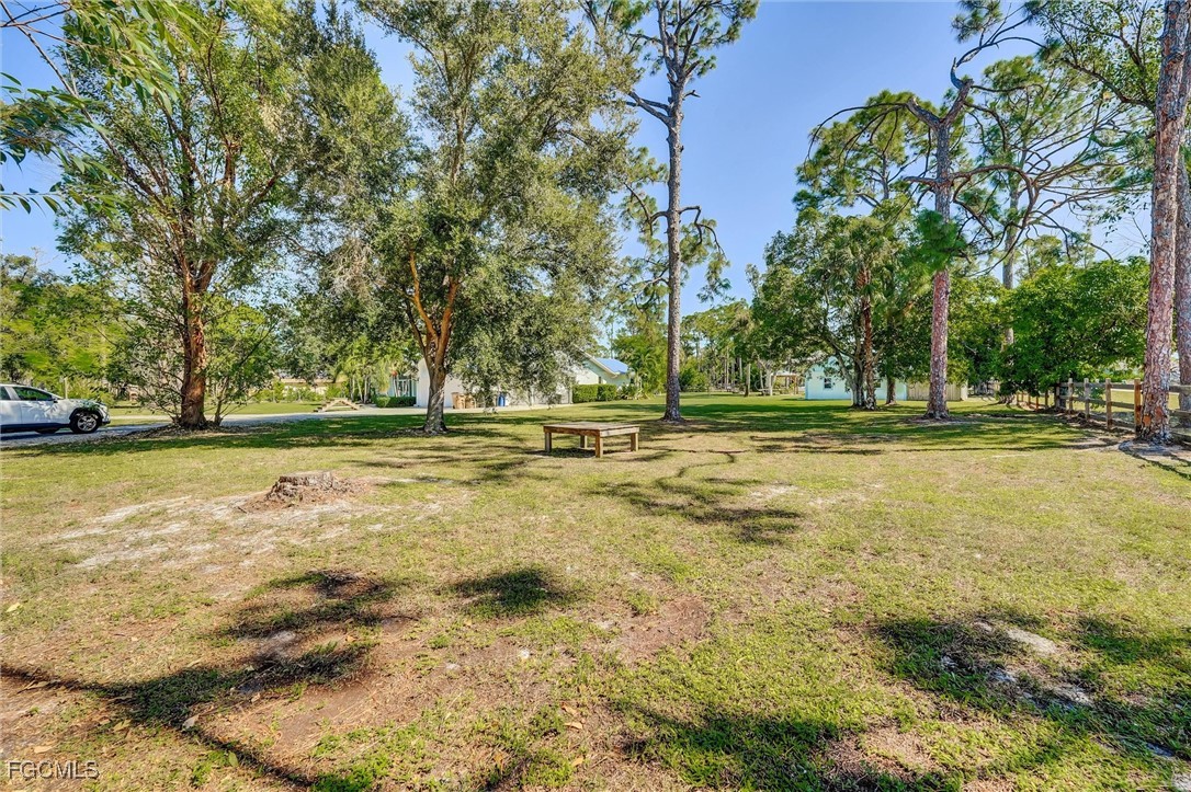 17040 Pleasure Road Cape Coral, FL 33909 - Photo 4 of 38 a view of outdoor space with swimming pool and trees