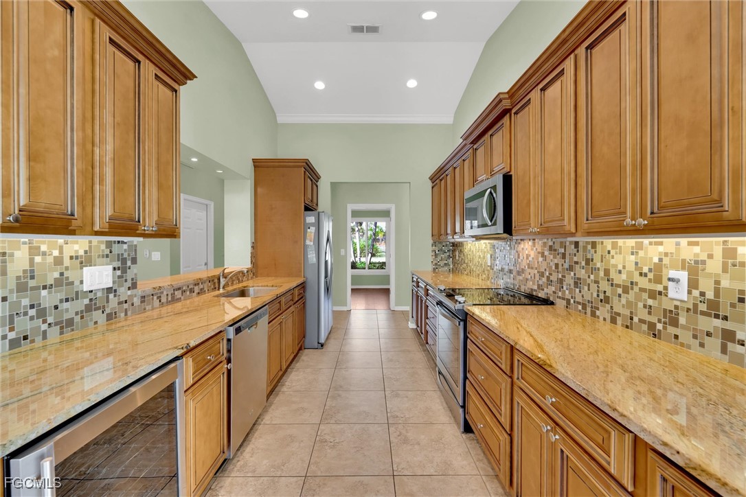 17040 Pleasure Road Cape Coral, FL 33909 - Photo 9 of 38 a large kitchen with stainless steel appliances granite countertop a sink and cabinets