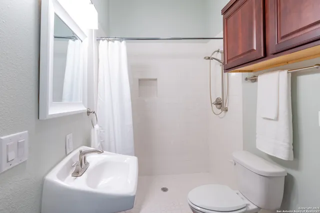 a bathroom with a toilet sink and shower