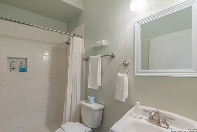 a bathroom with a toilet sink and shower