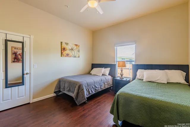 a bedroom with two beds and wooden floor
