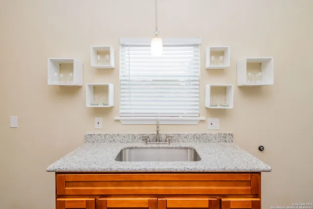 a view of a bathroom with a granite countertop sink and a mirror