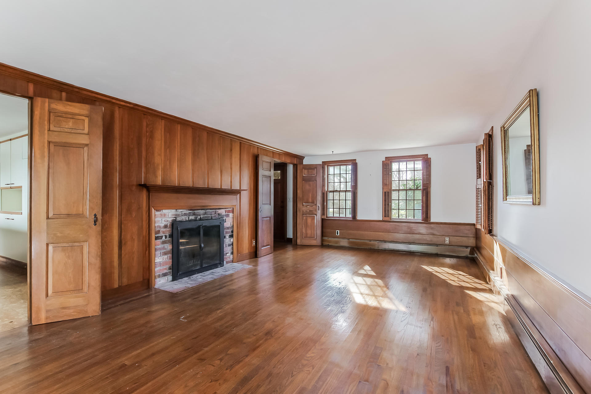 212 Holly Point Road Centerville, MA 02632 - Photo 7 of 30 a view of empty room with wooden floor and fireplace