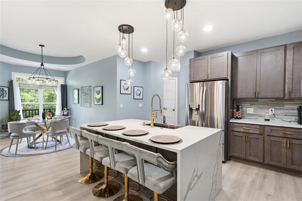 2021 Lakeview Parkway Villa Rica, GA 30180 - Photo 30 of 112 a kitchen with stainless steel appliances a dining table chairs and wooden floor
