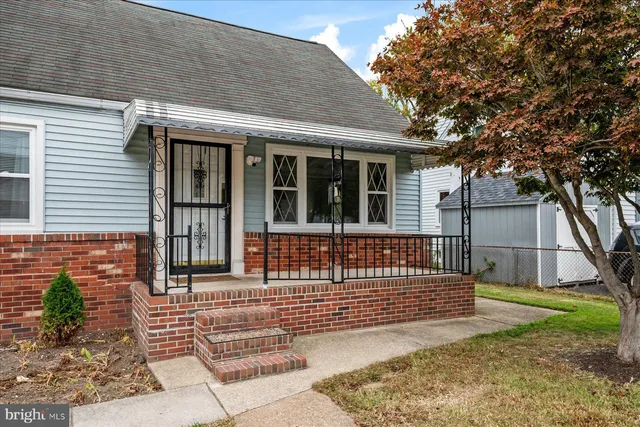 a view of a house with a small yard and wooden fence