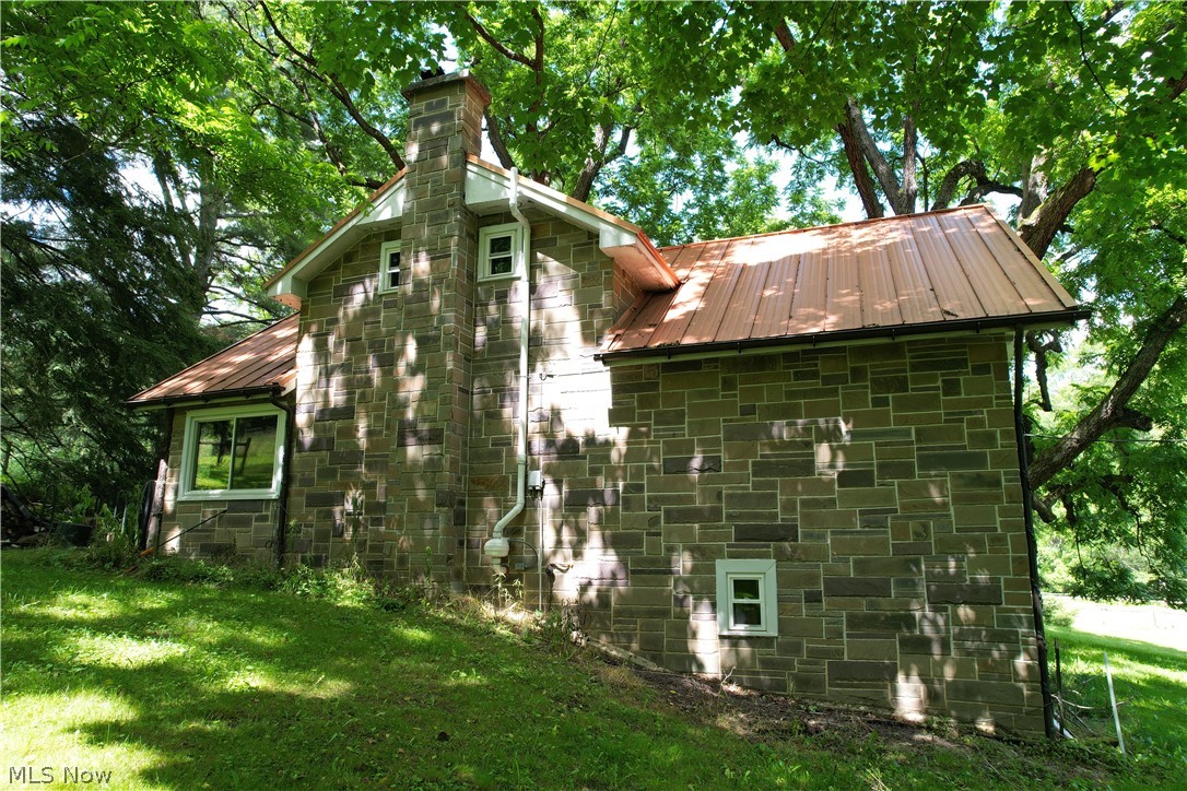 11811 Gaston Road Rogers, OH 44455 - Photo 9 of 38 The Cabin (stone-style facade) features 3 bedrooms, two bathrooms, a full-size basement, and is fully applianced with septic, well, and a geo-thermal furnace! Spend your evenings here while you build-out, or make the cabin your forever getaway and spend your days, hiking, hunting, or fishing!