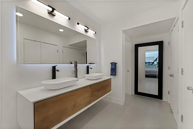 a large white room with a large mirror and vanity