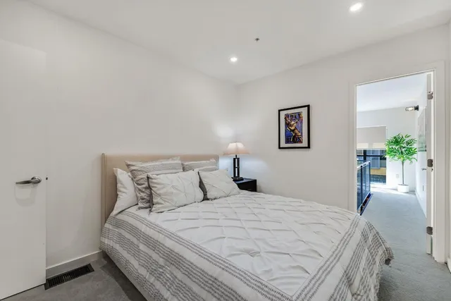a bedroom with a bed and a potted plant