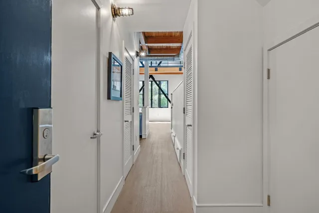 a view of a hallway with wooden floor and windows