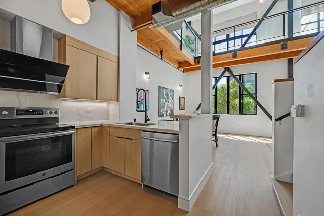 a kitchen with stainless steel appliances a stove a sink and a refrigerator