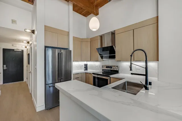 a kitchen with stainless steel appliances granite countertop a refrigerator a stove a sink and a microwave