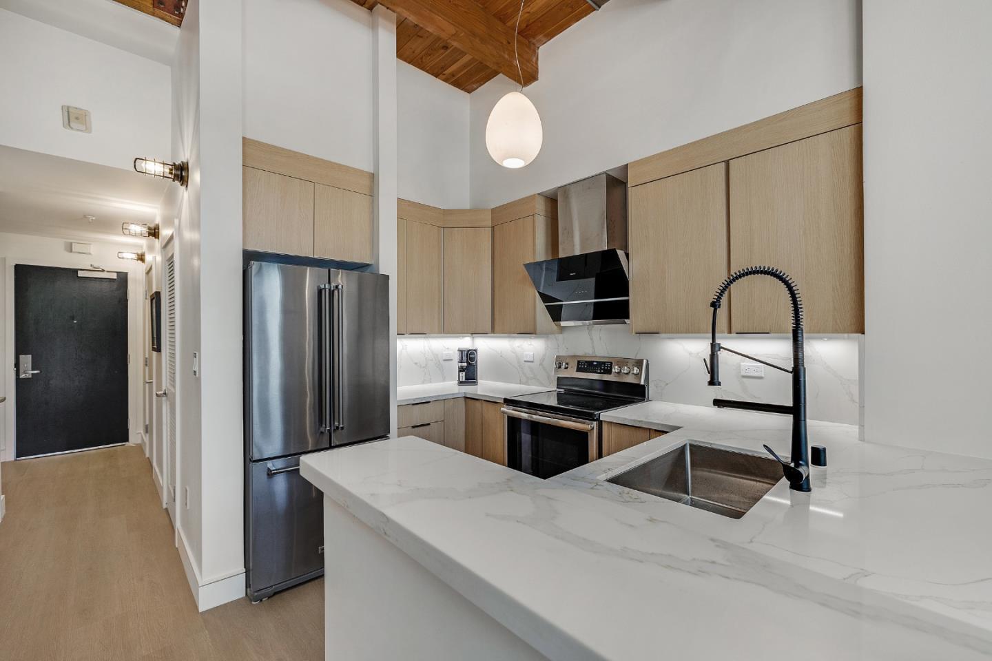333 Santana Row, Unit 224 San Jose, CA 95128 - Photo 8 of 30 a kitchen with stainless steel appliances granite countertop a refrigerator a stove a sink and a microwave