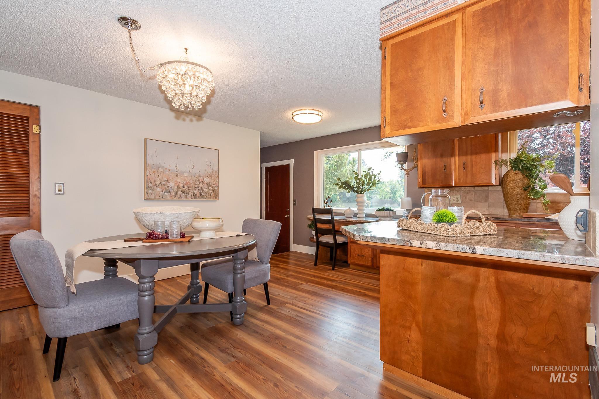 3706 West Clement Road Boise, ID 83704 - Photo 16 of 36 Warm wood cabinetry with granite countertops and stainless steel appliances anchors this open-concept kitchen and dining area