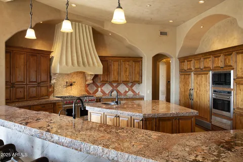 a kitchen with stainless steel appliances granite countertop a stove a sink and a refrigerator