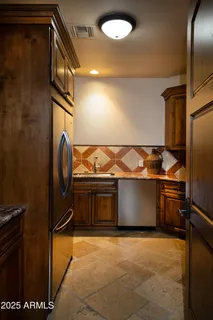 a kitchen with stainless steel appliances granite countertop a refrigerator and a stove