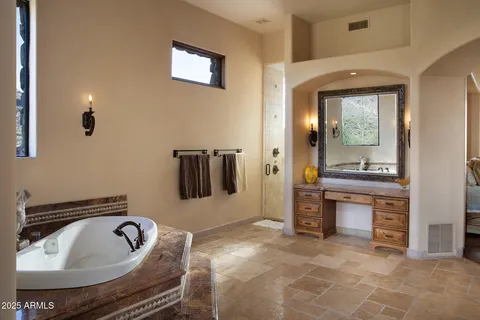 a spacious bathroom with a granite countertop tub sink and mirror