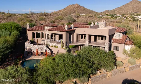 an aerial view of a house with a yard lake and mountain view