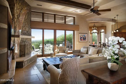 a living room with furniture potted plant and a large window