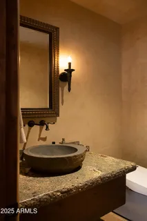 a spacious bedroom with a bed a dresser and a large mirror