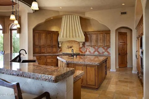 a kitchen with granite countertop a sink and a refrigerator