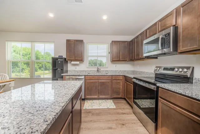 a kitchen with granite countertop a sink stove and refrigerator