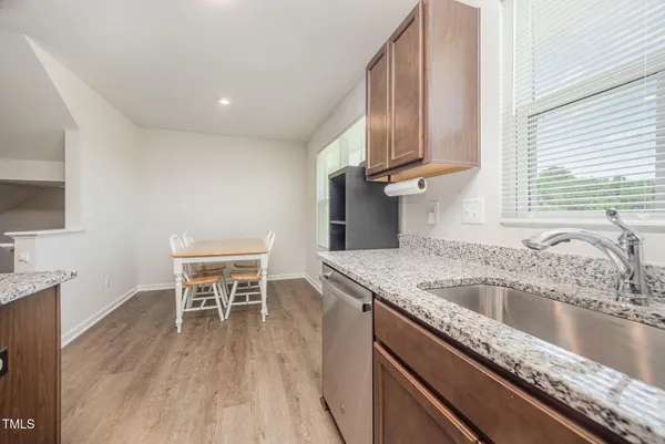 a kitchen with granite countertop a stove top oven a sink a counter space and cabinets