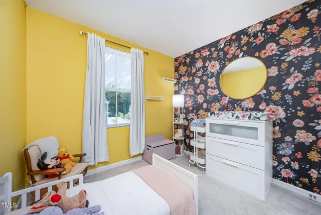 a bedroom with a bed and a flat tv screen on dresser