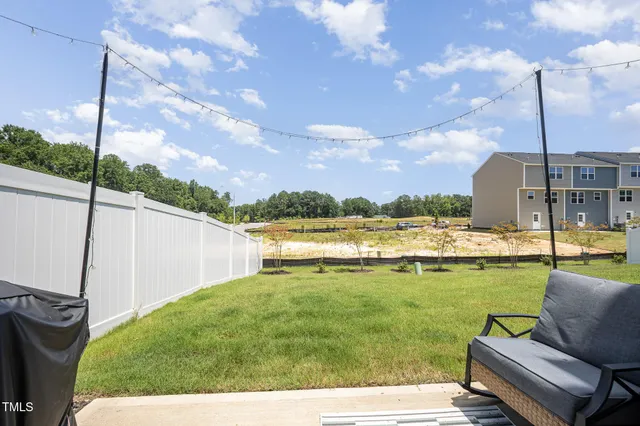 a view of a house with a yard and chairs