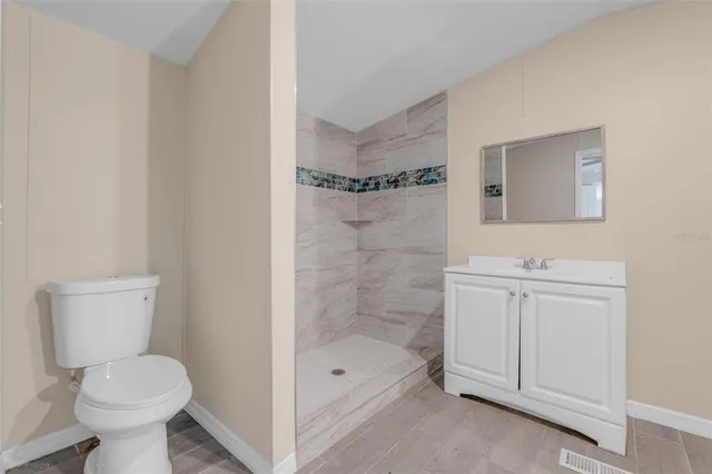 a bathroom with a shower a toilet and sink