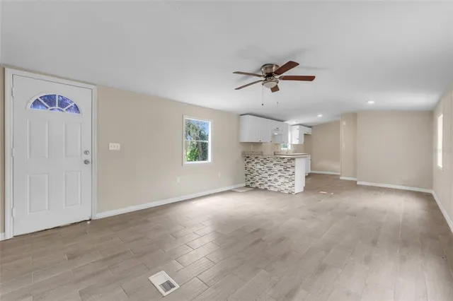 a view of a livingroom with a ceiling fan and window
