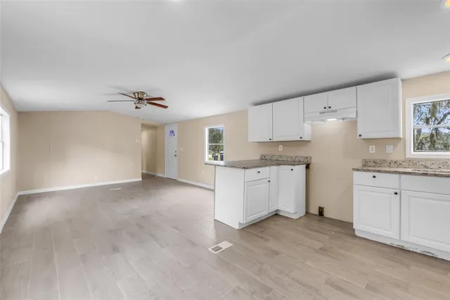 a kitchen with granite countertop white cabinets and white appliances