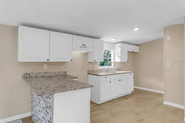 a kitchen with granite countertop white cabinets and white appliances